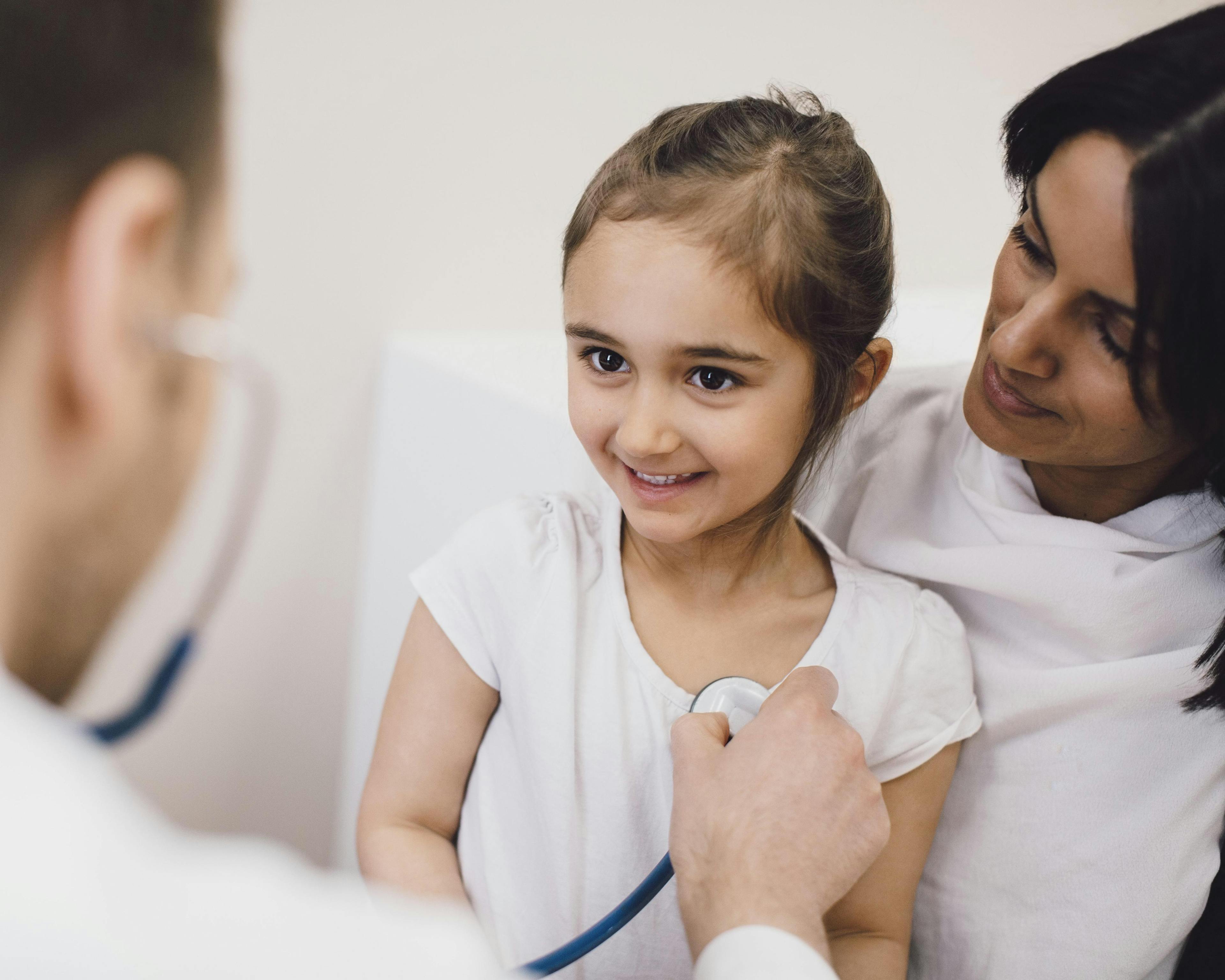 Male pediatrician checking girl