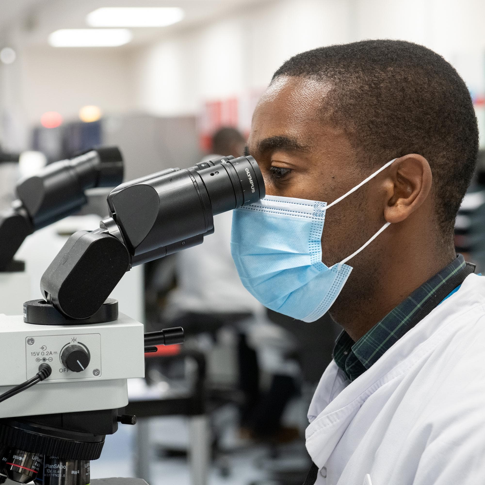 Technician looking into microscope